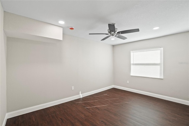 empty room with ceiling fan, recessed lighting, dark wood finished floors, and baseboards