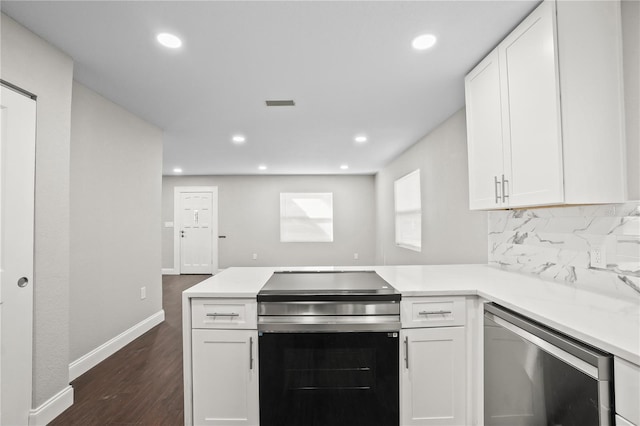 kitchen featuring stainless steel appliances, a peninsula, white cabinetry, light countertops, and backsplash