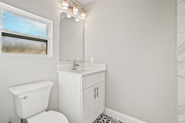 bathroom featuring vanity, toilet, and baseboards