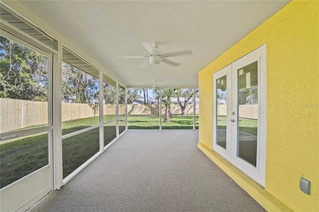 unfurnished sunroom featuring a ceiling fan