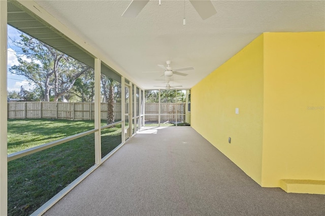 unfurnished sunroom with a ceiling fan