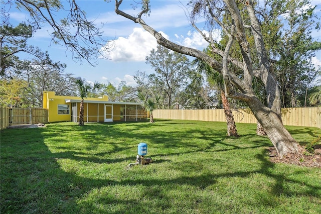 view of yard with a fenced backyard and a sunroom