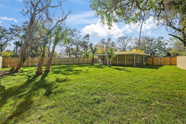 view of yard with a fenced backyard and a sunroom