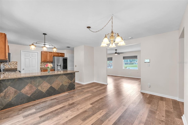 2412 Giddens Ave, Seffner, FL 33584 - kitchen featuring stainless steel fridge with ice dispenser, a chandelier, brown cabinets, a peninsula, and wood finished floors