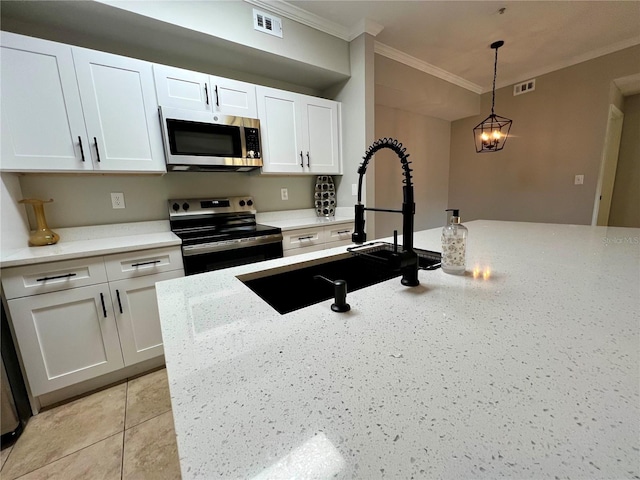 kitchen with visible vents, appliances with stainless steel finishes, hanging light fixtures, crown molding, and white cabinetry