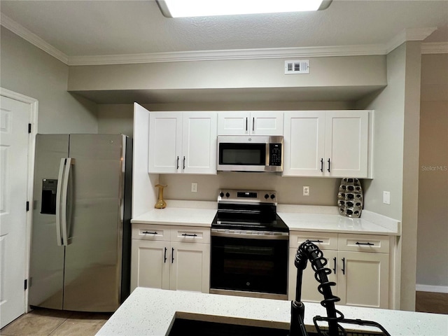 kitchen featuring stainless steel appliances, white cabinetry, visible vents, and crown molding