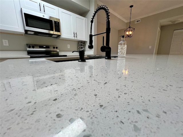 kitchen featuring visible vents, white cabinets, decorative light fixtures, stainless steel appliances, and speckled floor