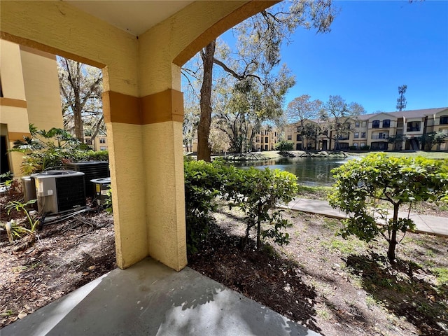 view of patio with central air condition unit, a water view, and a residential view