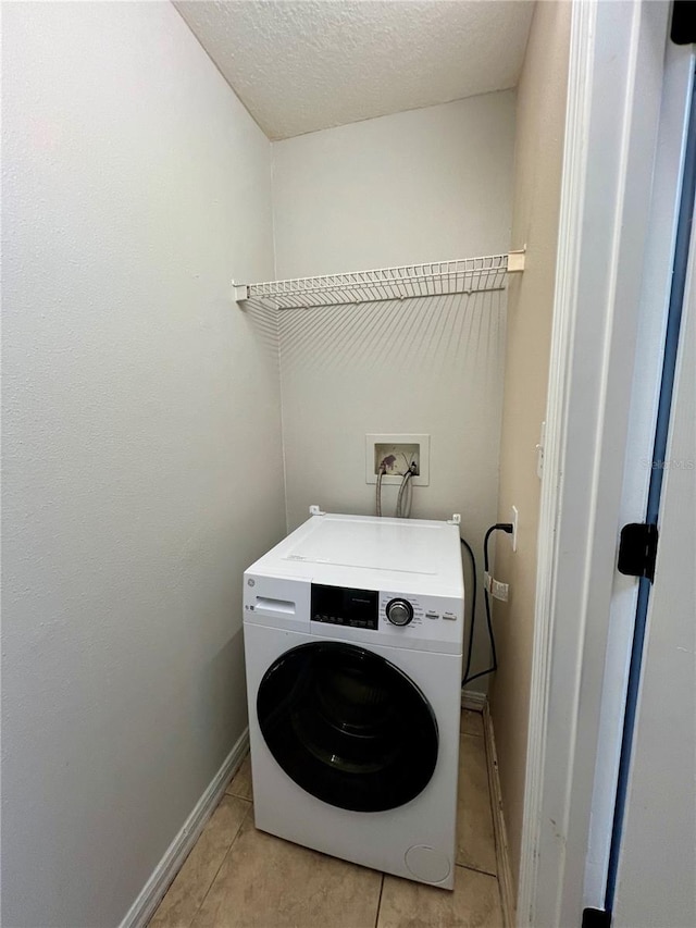 washroom featuring laundry area, light tile patterned floors, washer / dryer, baseboards, and a textured ceiling