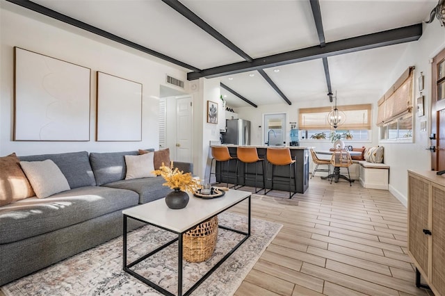 living room featuring visible vents, lofted ceiling with beams, wood tiled floor, a chandelier, and baseboards