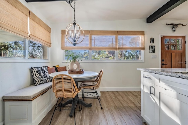 dining space with a healthy amount of sunlight, light wood-style flooring, breakfast area, and beam ceiling