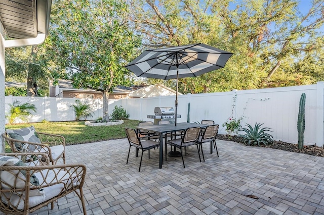 view of patio / terrace with outdoor dining area, a fenced backyard, and a grill