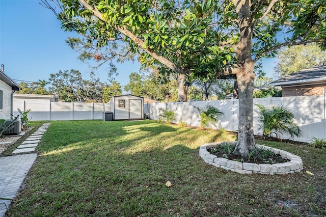 view of yard with a shed, a fenced backyard, and an outbuilding