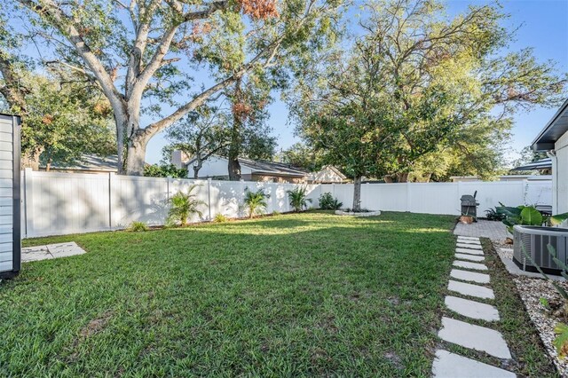 view of yard with a fenced backyard and cooling unit