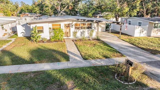 view of front of home with driveway, fence, and a front yard