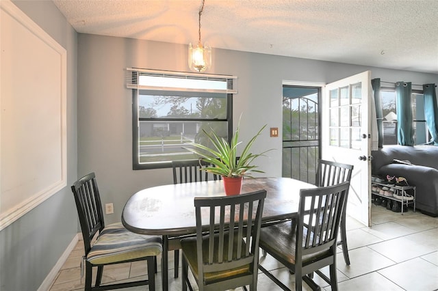 dining room with baseboards, plenty of natural light, and a textured ceiling