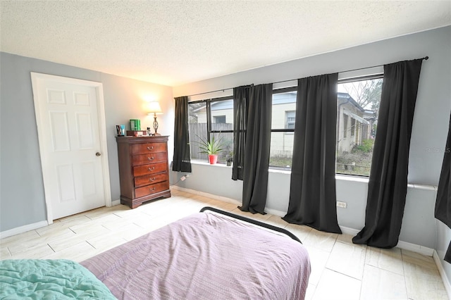 bedroom featuring baseboards and a textured ceiling