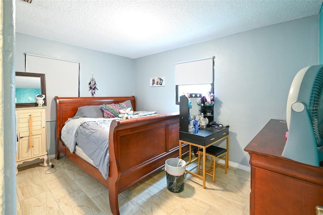 bedroom featuring baseboards and a textured ceiling