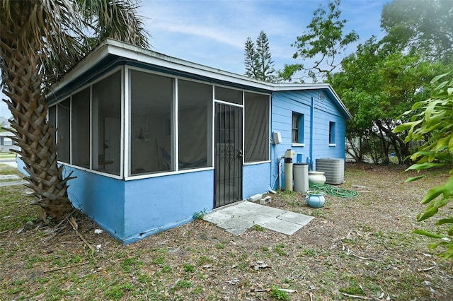 view of side of property featuring central AC and a sunroom