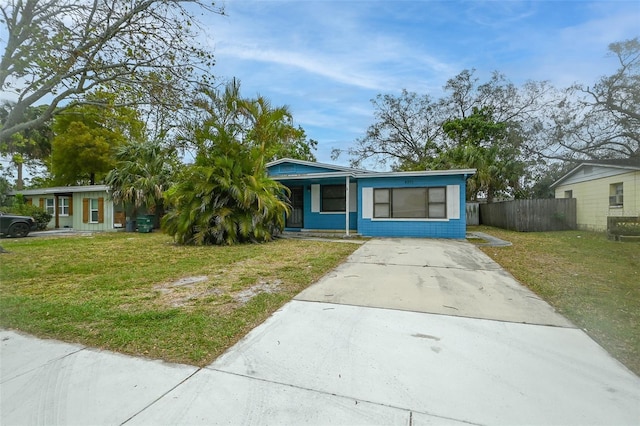 bungalow featuring driveway, a front lawn, and fence