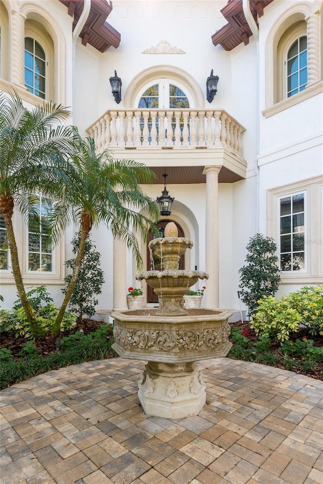 entrance to property featuring a balcony and stucco siding