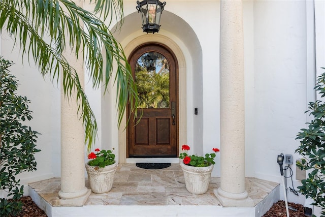 doorway to property featuring stucco siding