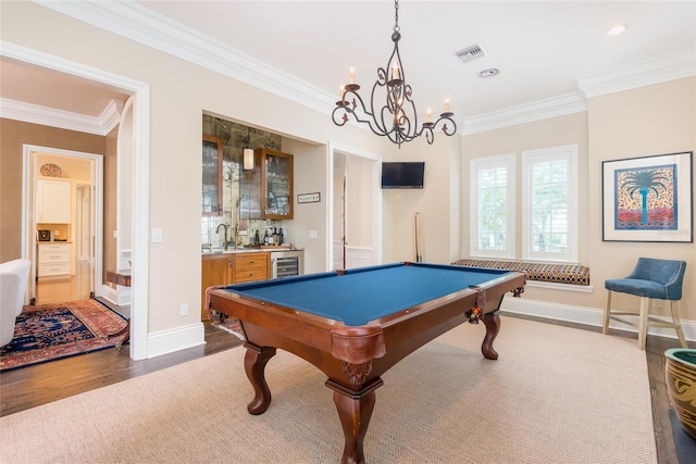 playroom with wine cooler, indoor wet bar, visible vents, ornamental molding, and wood finished floors