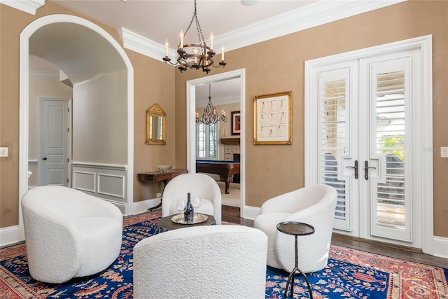 living area with ornamental molding, a healthy amount of sunlight, and wood finished floors