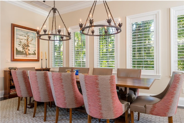 dining space with a notable chandelier, baseboards, and crown molding