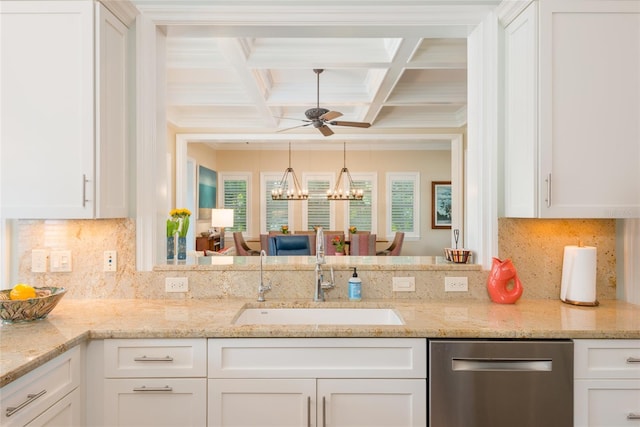 kitchen featuring stainless steel dishwasher, white cabinetry, a sink, coffered ceiling, and ceiling fan with notable chandelier