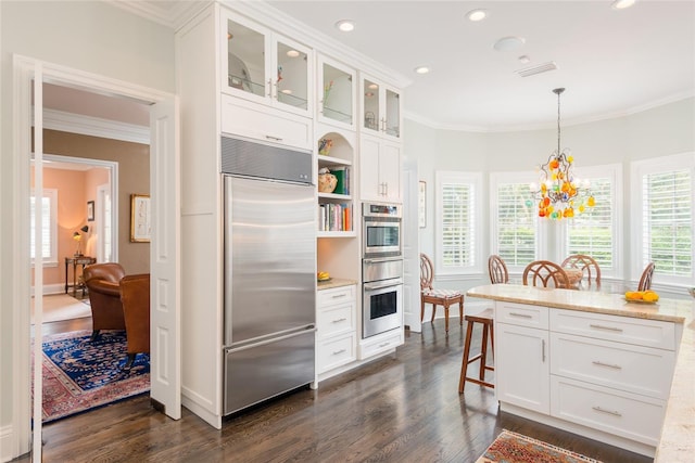 kitchen featuring appliances with stainless steel finishes, dark wood-style flooring, crown molding, and a kitchen bar