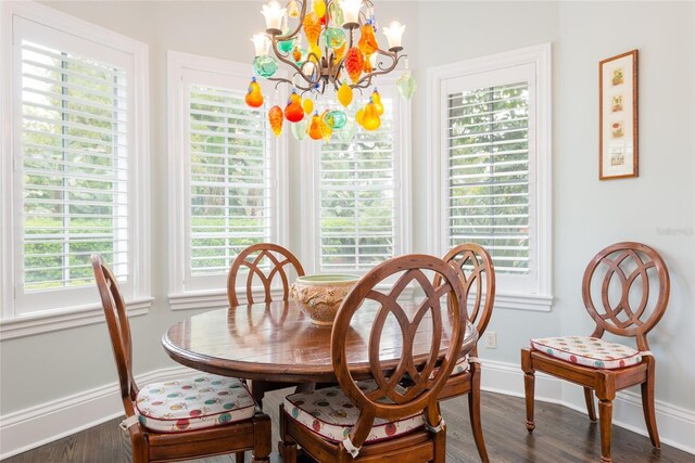 dining space featuring an inviting chandelier, baseboards, and dark wood-style flooring