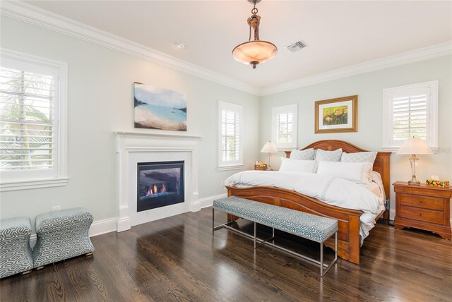 bedroom with ornamental molding, wood finished floors, visible vents, and multiple windows