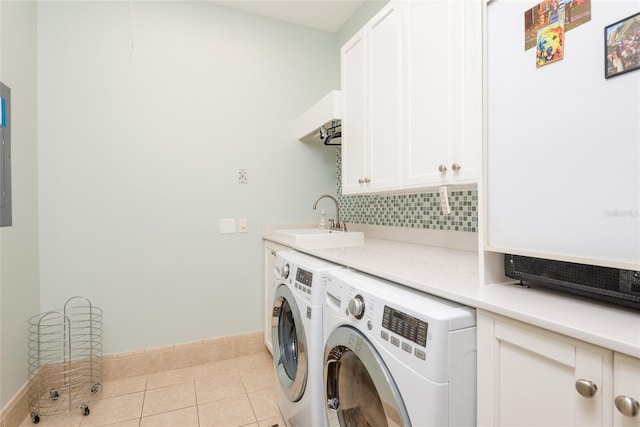 laundry area featuring light tile patterned flooring, a sink, baseboards, cabinet space, and washing machine and clothes dryer