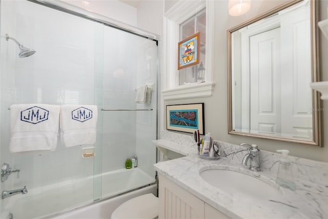 full bath featuring toilet, combined bath / shower with glass door, and vanity