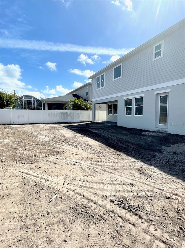 rear view of property with fence and stucco siding