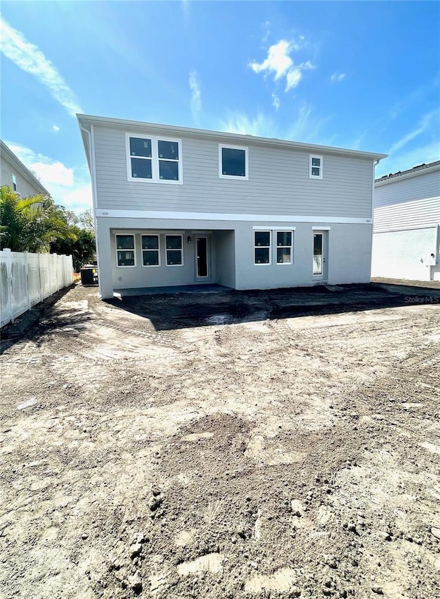 back of house featuring central AC and fence