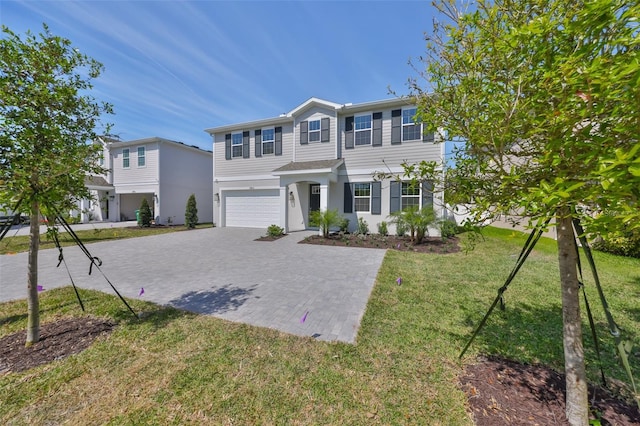 view of front of house featuring stucco siding, a front yard, decorative driveway, and a garage