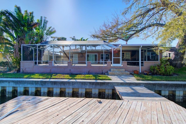 rear view of house featuring glass enclosure