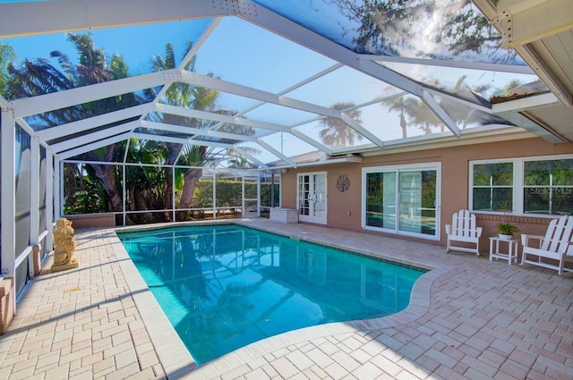 pool with glass enclosure and a patio area