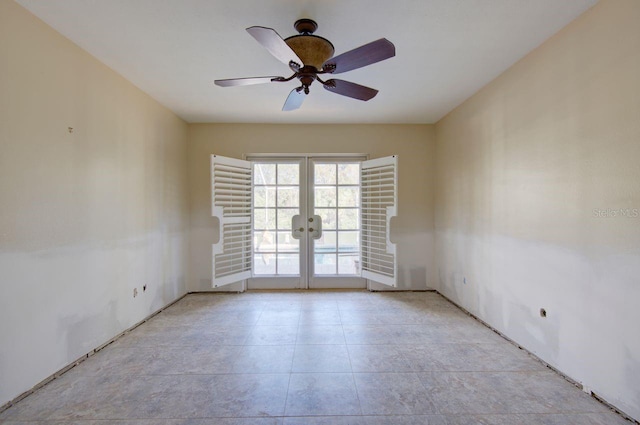 spare room with a ceiling fan and french doors