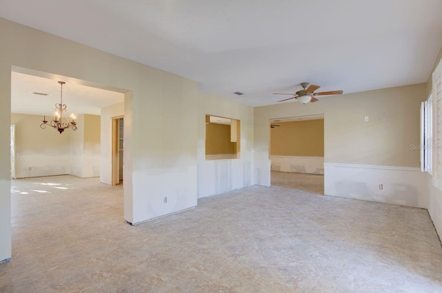 unfurnished room with ceiling fan with notable chandelier