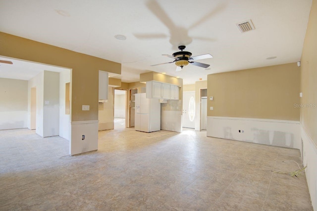 unfurnished living room with visible vents and a ceiling fan