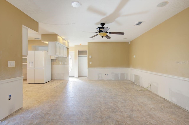 unfurnished living room with ceiling fan and visible vents