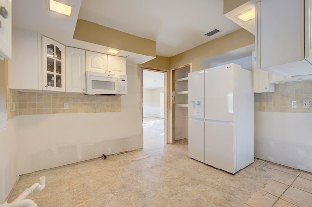 kitchen with white appliances, tasteful backsplash, visible vents, glass insert cabinets, and white cabinetry