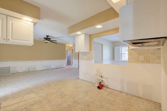 kitchen with light countertops, white cabinets, and ceiling fan