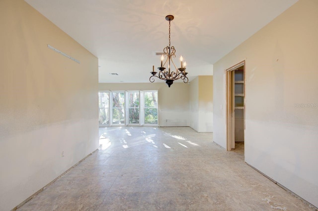 unfurnished room with a chandelier