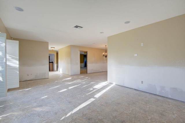 unfurnished room featuring visible vents and a notable chandelier