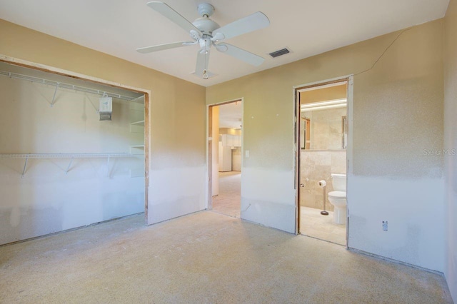 unfurnished bedroom featuring a ceiling fan, visible vents, a closet, and ensuite bathroom