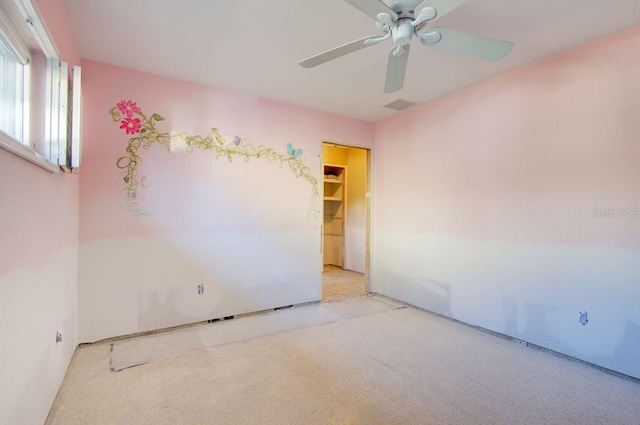 carpeted empty room featuring ceiling fan and visible vents